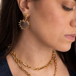 Model wearing Lanamara Open Hearted clear quartz heart earrings with gold link chains