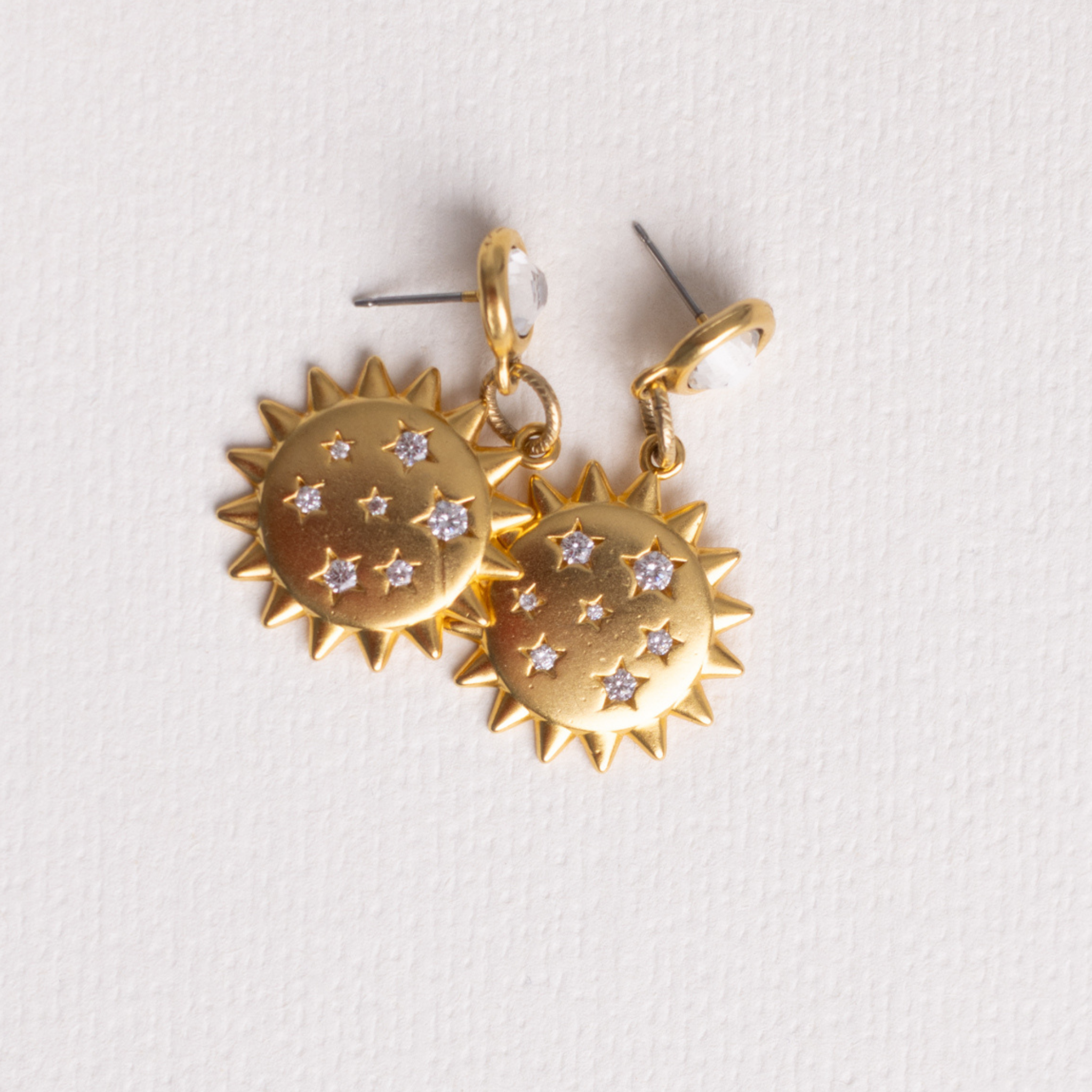 Close-up of Lanamara Intuition Sunstar gold drop earrings with etched CZ stars