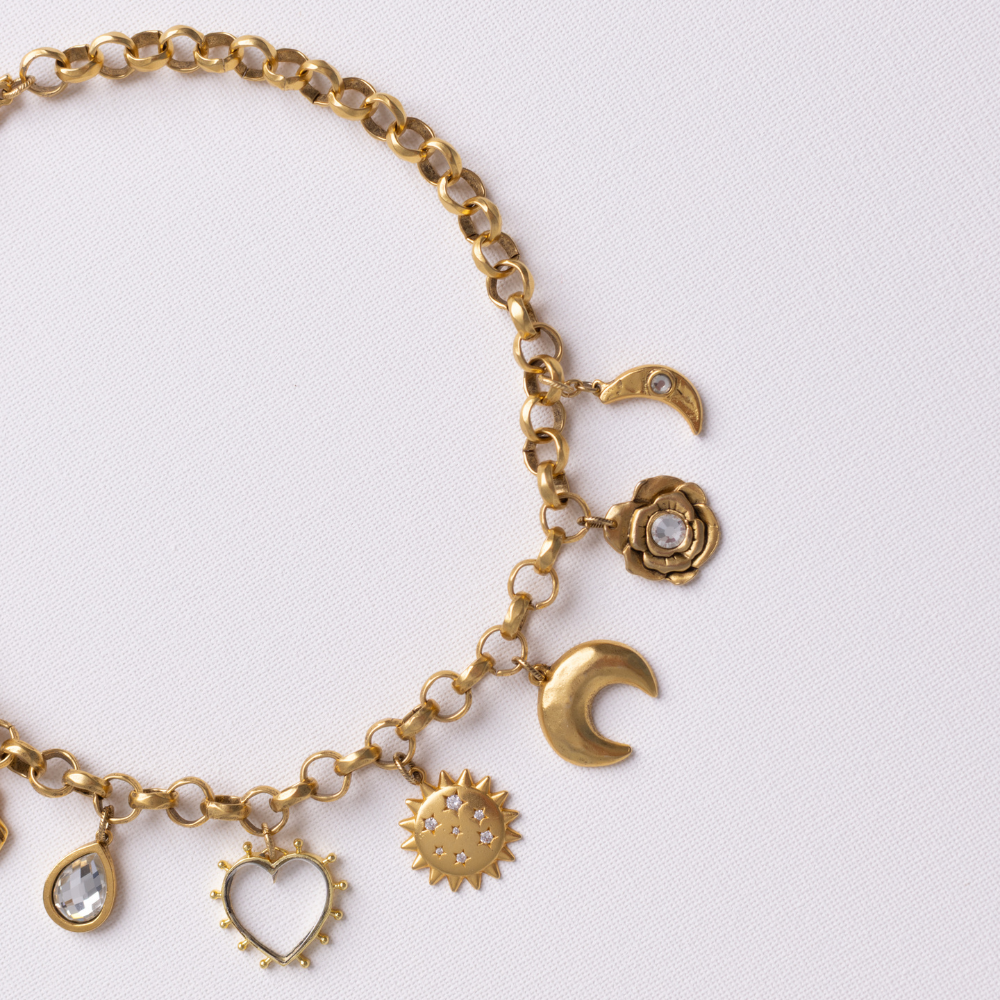 Close-up of Lanamara Celestial Charm Necklace charms — crescent moon, crystal rose and CZ sunstar in gold