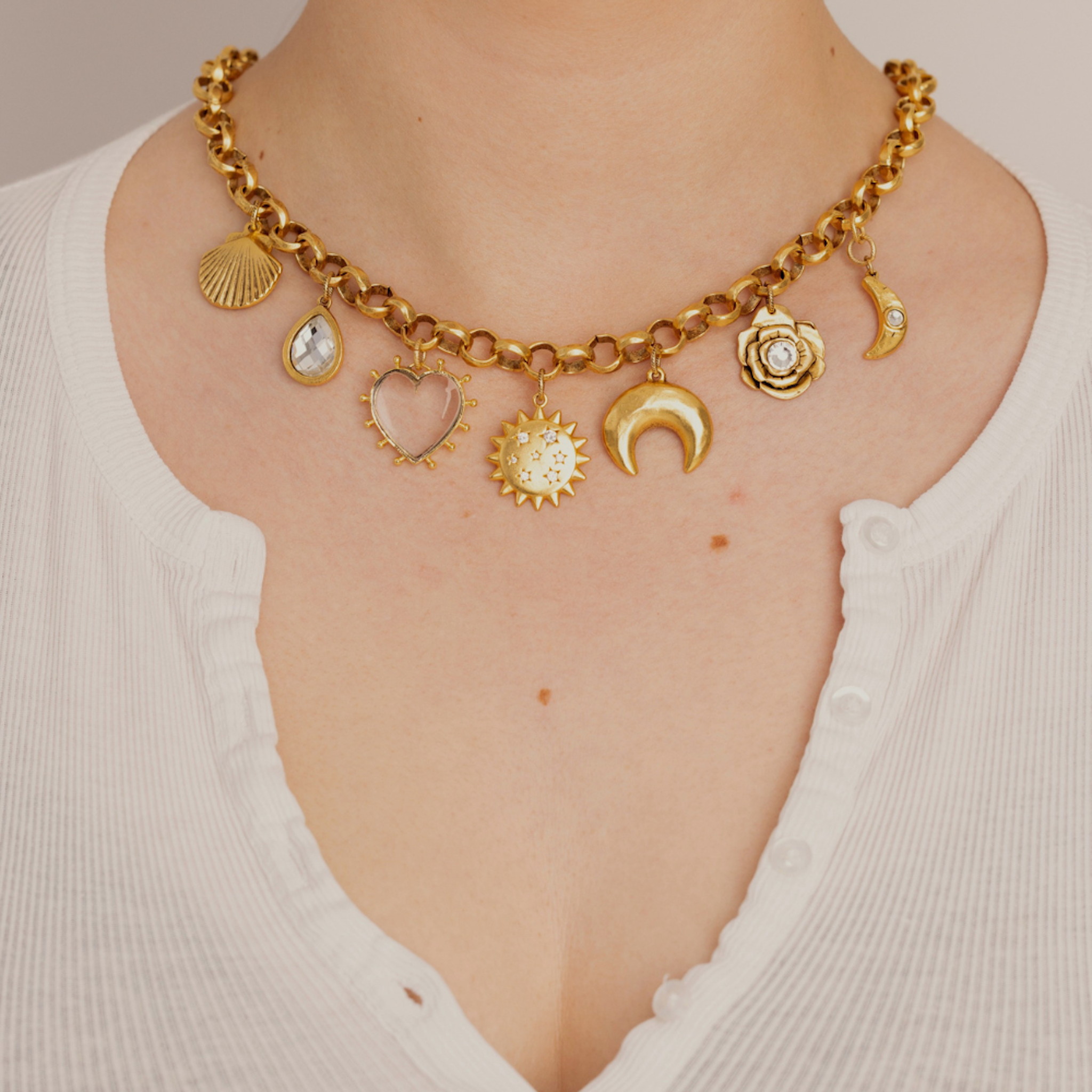Model wearing the Lanamara Celestial Charm Necklace in gold with sun, moon and star charms
