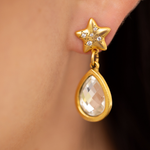 Close-up of Lanamara gold star stud earring with CZ stars and faceted Swarovski teardrop