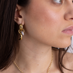 Model wearing Lanamara Celestial gold crescent moon huggie earrings