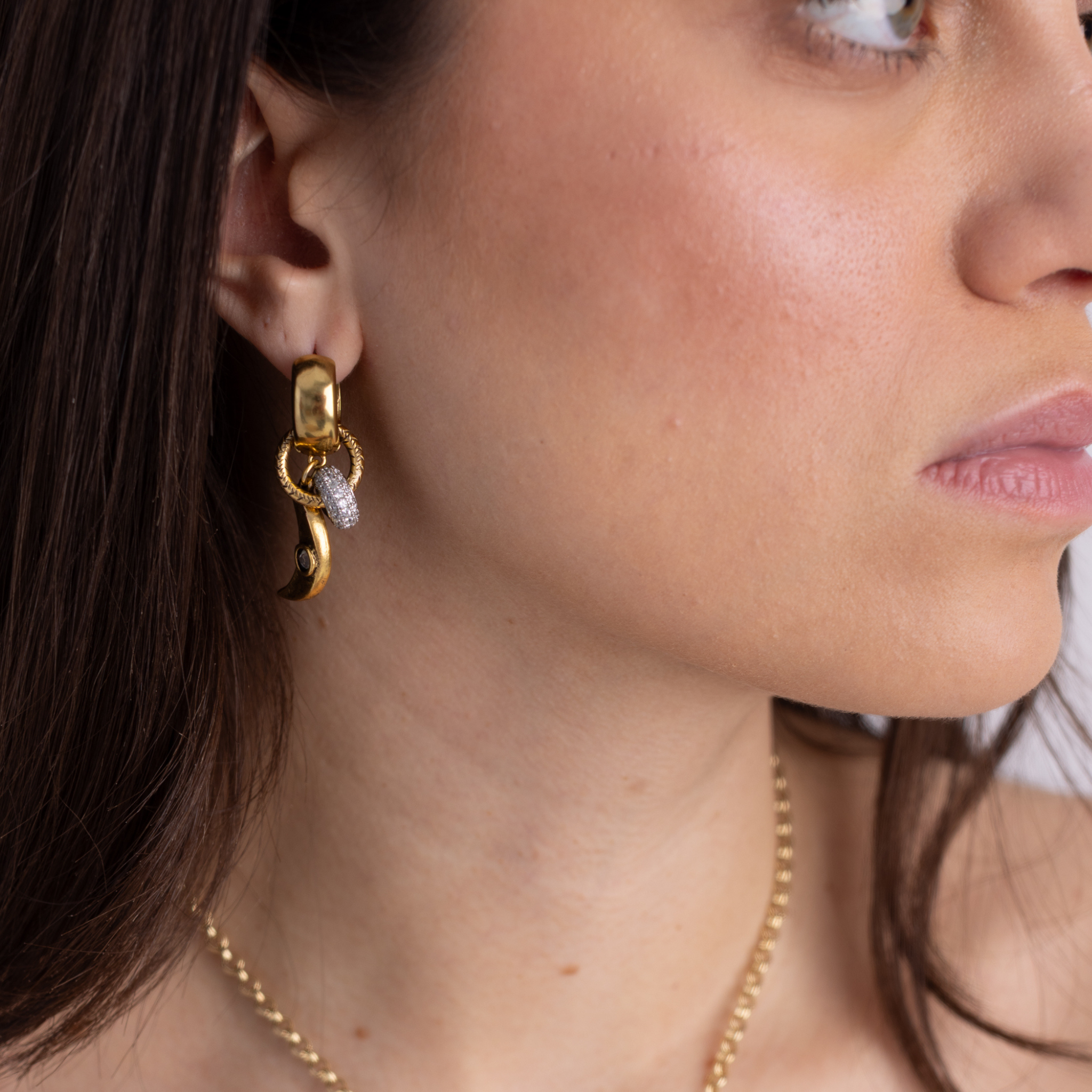 Model wearing Lanamara Celestial gold crescent moon huggie earrings