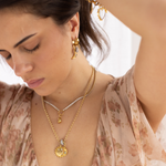Model wearing Lanamara Celestial Huggies with the Celestial pendant and charm necklaces