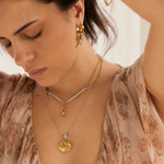 Lanamara Celestial sun and moon pendant necklace worn layered, on model
