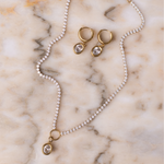Lanamara Clarity Tennis Necklace – Oval with matching oval huggie earrings on marble