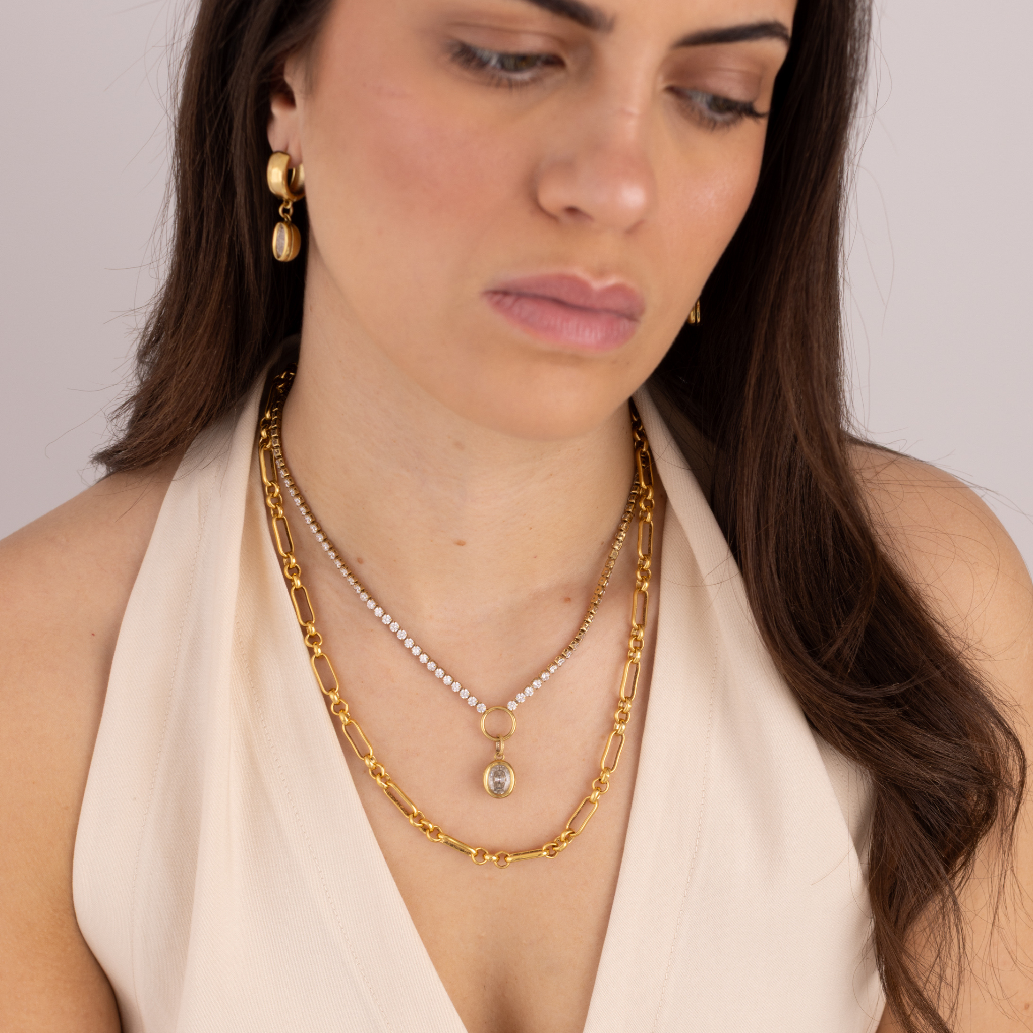 Model wearing Lanamara Clarity oval tennis necklace layered with the Heirloom gold chain necklace
