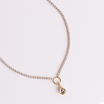 Lanamara Clarity pear tennis necklace with bezel-set pear pendant on O-ring, flat lay