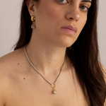 Model wearing Lanamara Clarity pear tennis necklace with matching pear huggie earrings