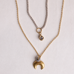 Lanamara Intuition gold crescent moon necklace layered with bezel tennis necklace, flat lay
