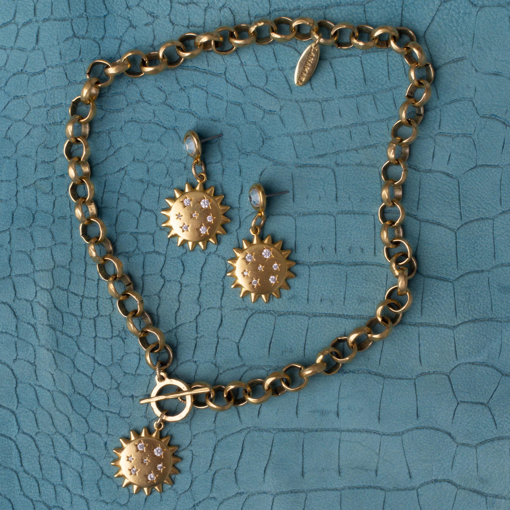 Lanamara Intuition Sunstar necklace and matching earrings styled on teal