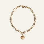 Lanamara Sunstar Necklace — matte gold sun pendant with CZ stars on artisan chain with toggle