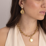 Model wearing Lanamara Intuition Sunstar gold pendant necklace with matching earrings