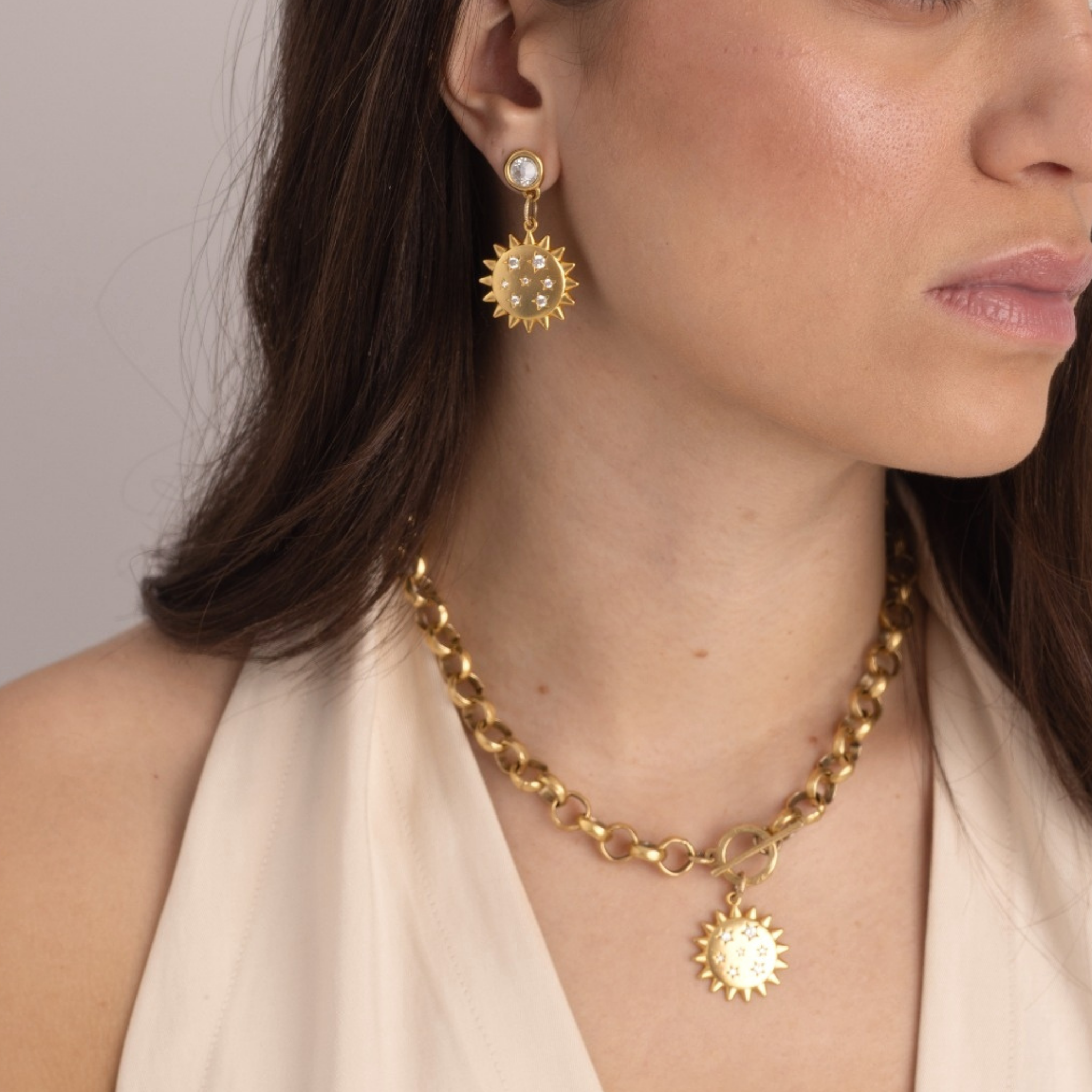 Model wearing Lanamara Intuition Sunstar gold pendant necklace with matching earrings