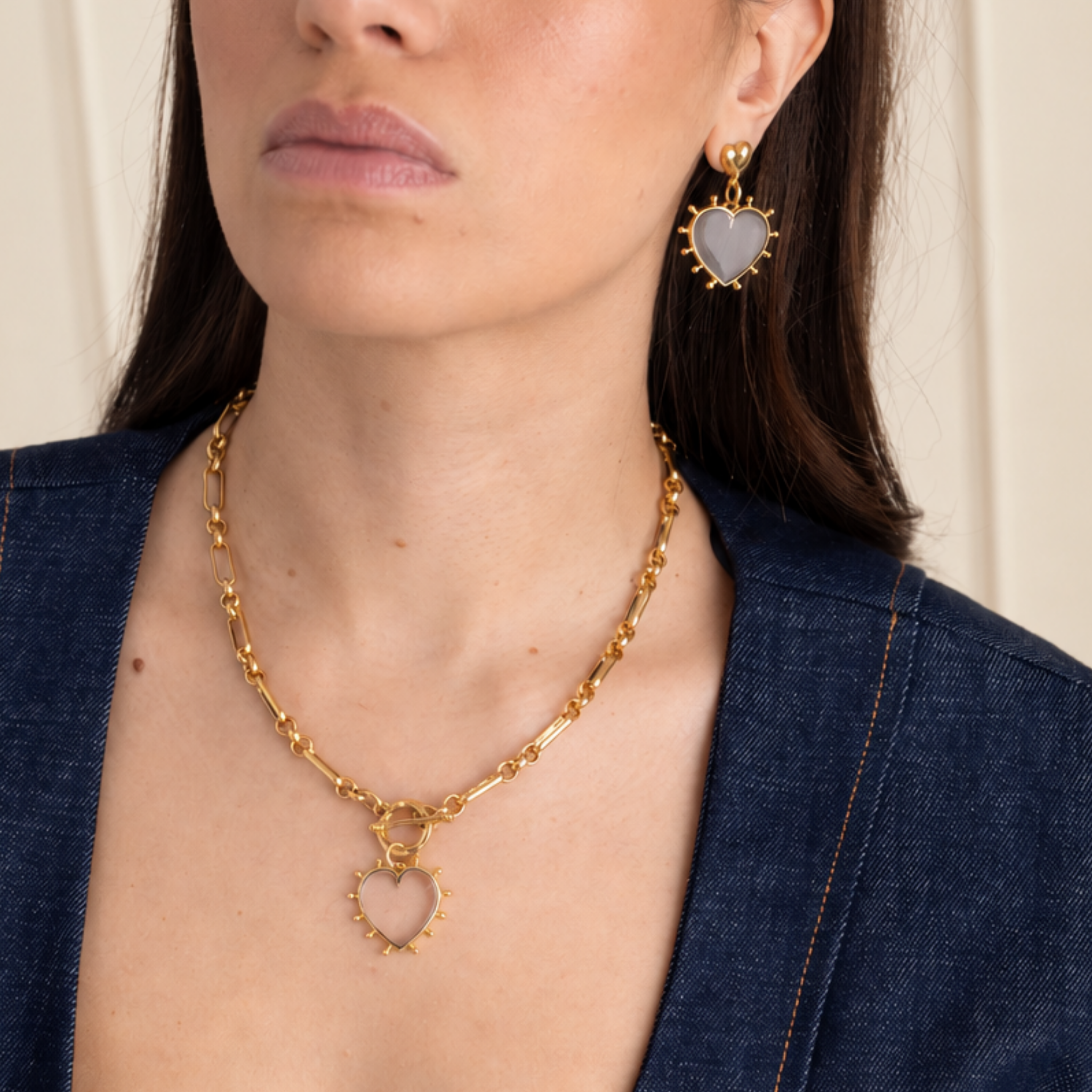 Model wearing Lanamara Open Hearted clear quartz heart earrings with the open heart pendant necklace