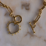 Close-up of Lanamara clear quartz open heart pendant with gold beaded edging and toggle