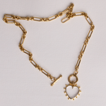 Full length of Lanamara Open Hearted gold heirloom chain necklace with clear quartz heart, flat lay