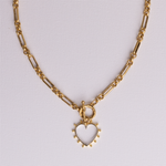 Clear quartz open heart pendant and front toggle clasp on gold heirloom chain, flat lay