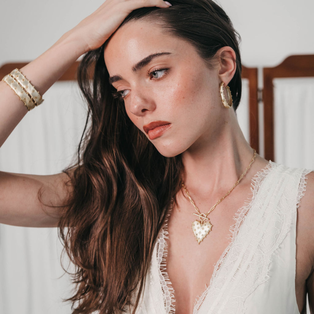 Model wearing the Lanamara Heart Stopper Necklace, a gold heart pendant on a paperclip chain