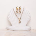 Lanamara Vintage Clarity oval huggies with matching Clarity tennis necklace on a shell stand
